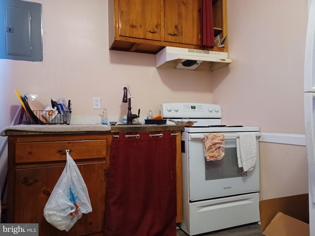 kitchen with brown cabinets, under cabinet range hood, electric panel, and electric range