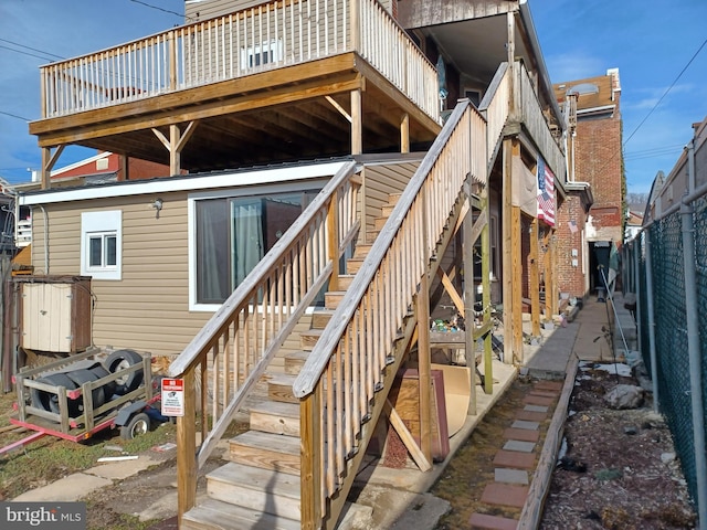 back of house with stairway, fence, and a wooden deck