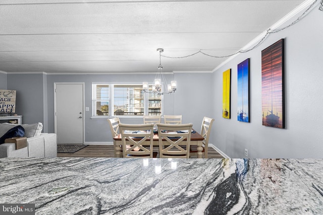 dining area with a chandelier, crown molding, baseboards, and wood finished floors