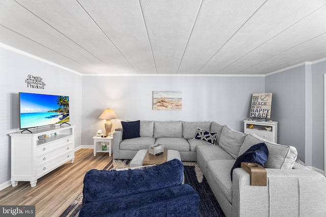 living area with crown molding, light wood-style flooring, and baseboards