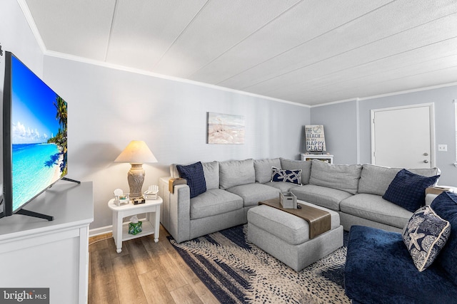 living area featuring baseboards, wood finished floors, and crown molding