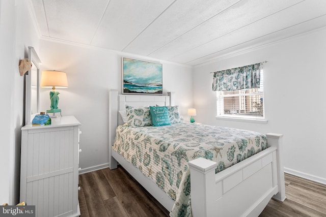 bedroom with crown molding, wood finished floors, and baseboards