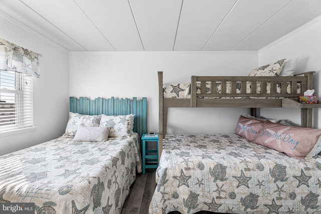 bedroom featuring wood finished floors and ornamental molding