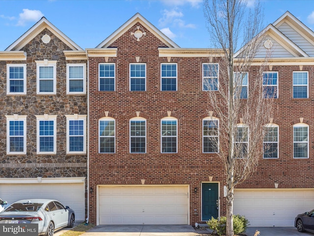 view of property with a garage, brick siding, and driveway