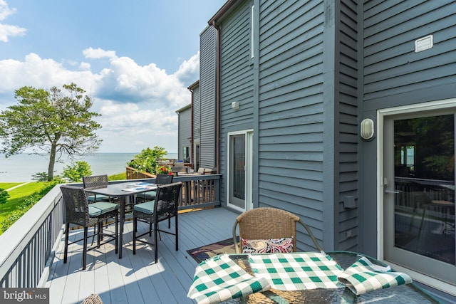 wooden terrace with outdoor dining area and a water view