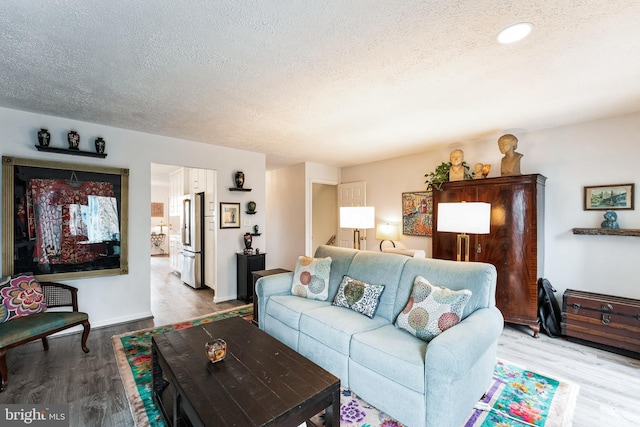 living room with a textured ceiling and wood finished floors