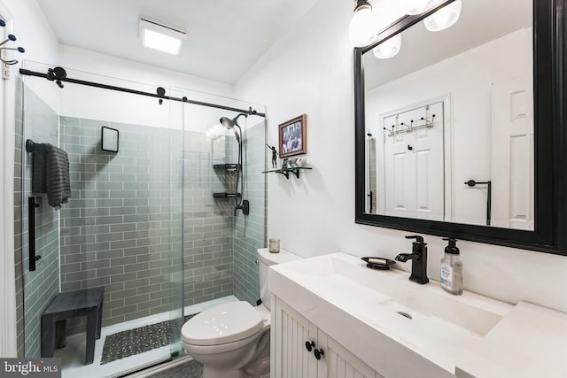 full bathroom featuring a stall shower, vanity, and toilet