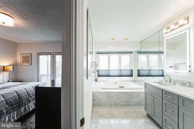 bathroom featuring a textured ceiling, ensuite bathroom, a garden tub, vanity, and marble finish floor