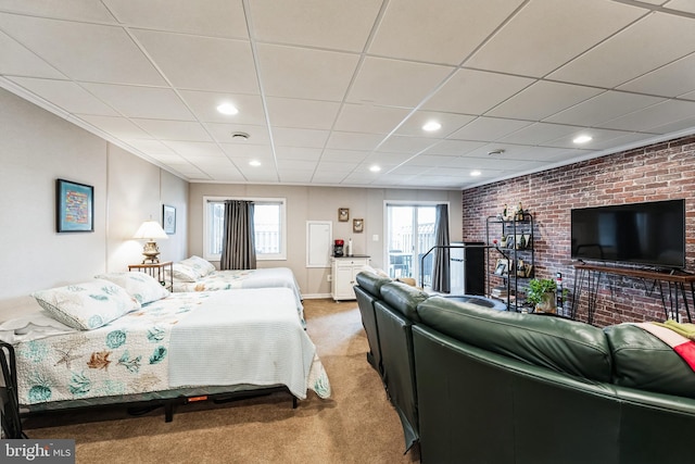 carpeted bedroom with brick wall, a drop ceiling, and recessed lighting