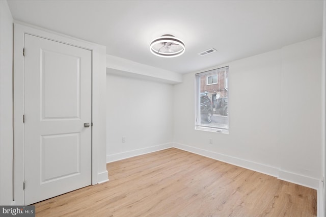 unfurnished room featuring visible vents, baseboards, and light wood finished floors