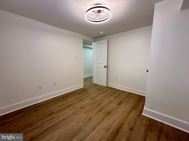 spare room with baseboards and wood finished floors