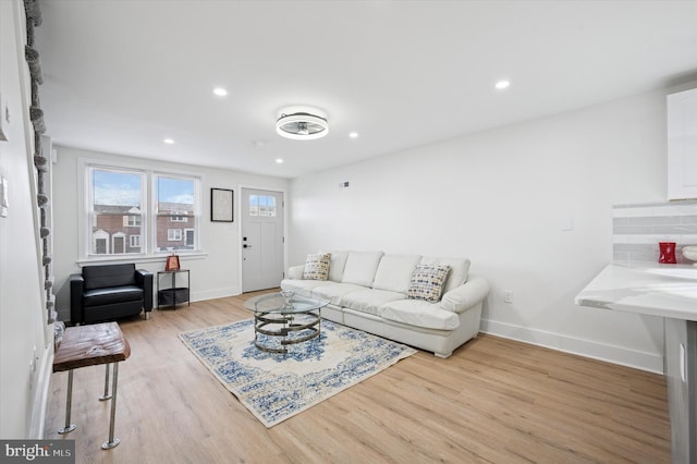 living area with recessed lighting, baseboards, and light wood finished floors