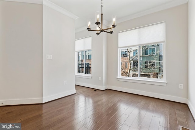 unfurnished dining area with a chandelier, baseboards, wood finished floors, and crown molding