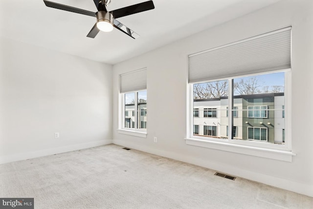 spare room featuring baseboards, carpet, visible vents, and a ceiling fan