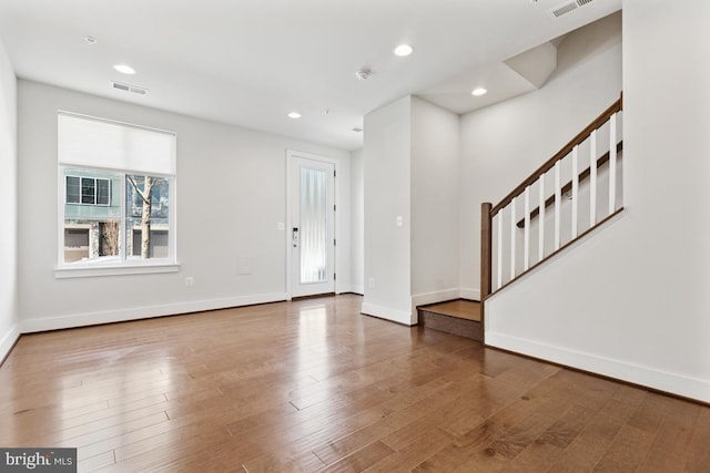 foyer with recessed lighting, wood finished floors, visible vents, baseboards, and stairs