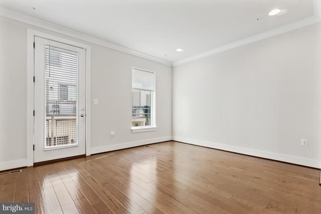 spare room with recessed lighting, visible vents, ornamental molding, wood finished floors, and baseboards