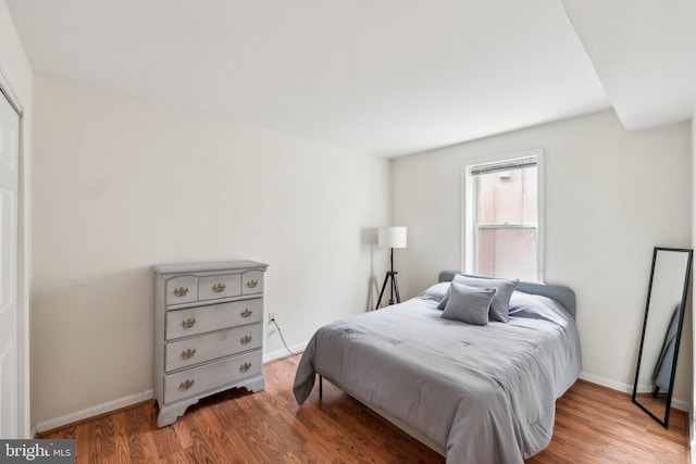 bedroom with wood finished floors and baseboards