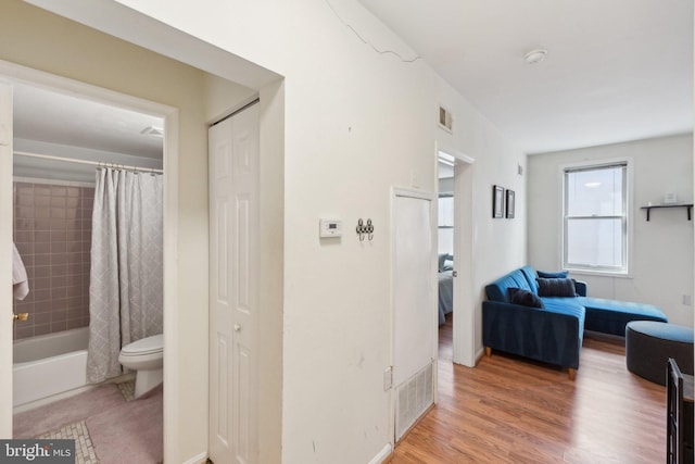 hall featuring visible vents and wood finished floors