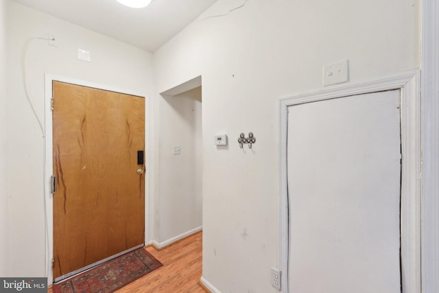 entryway with light wood finished floors and baseboards