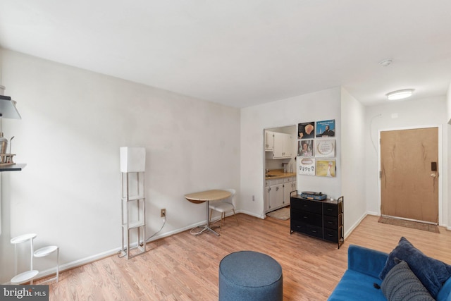 living area with light wood-type flooring and baseboards