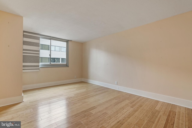 unfurnished room with baseboards and wood finished floors