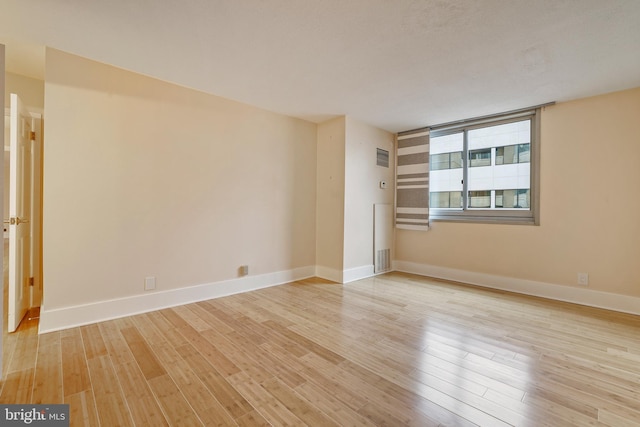 empty room featuring baseboards and wood finished floors