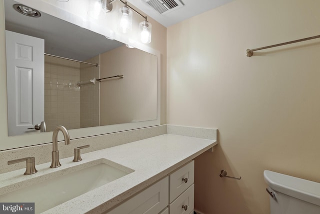 bathroom with visible vents, toilet, walk in shower, and vanity