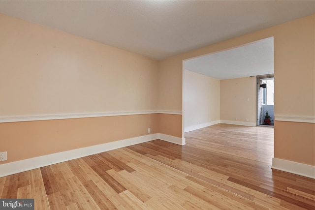 unfurnished room with baseboards and light wood-style floors