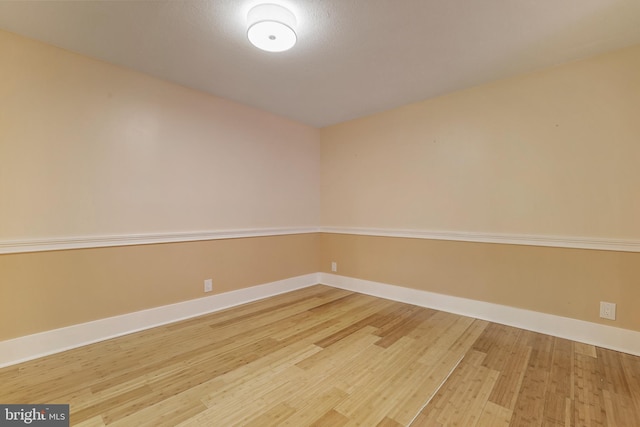 empty room with baseboards and wood finished floors