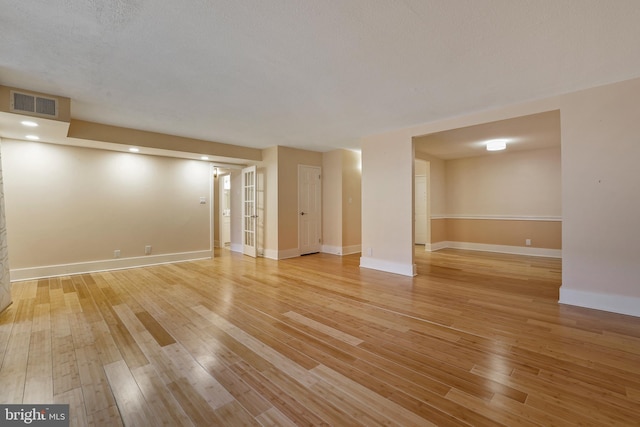 basement with visible vents, baseboards, and light wood-style floors