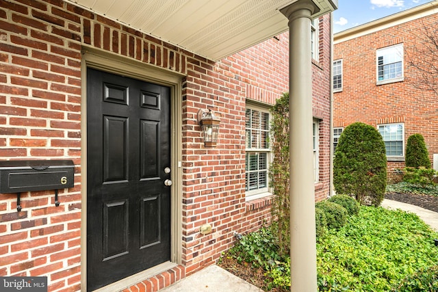 doorway to property featuring brick siding