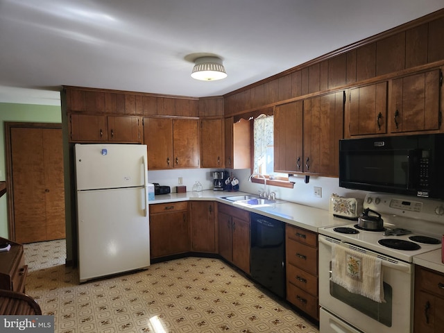 kitchen with light floors, light countertops, a sink, and black appliances