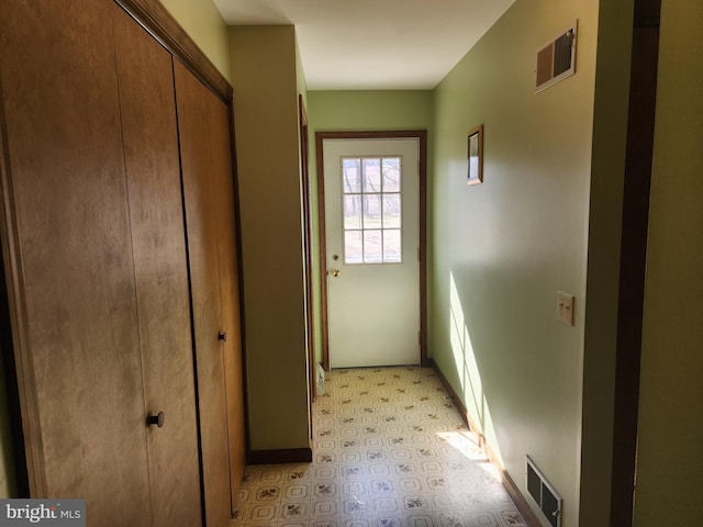 doorway with light floors and visible vents