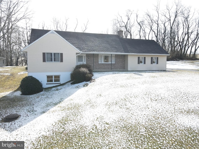 single story home with brick siding and a chimney