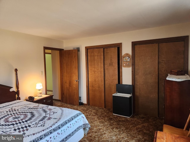 carpeted bedroom with visible vents and two closets