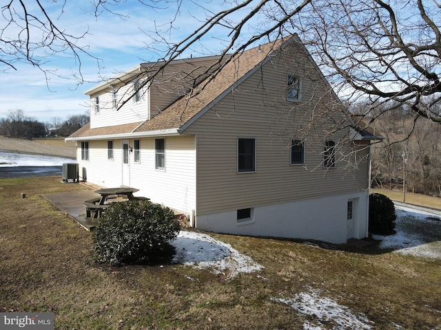 view of home's exterior featuring a shingled roof and central air condition unit