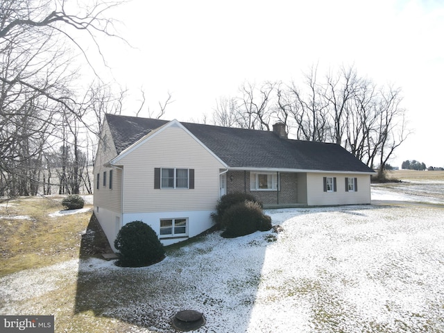 view of front of home with brick siding and a chimney