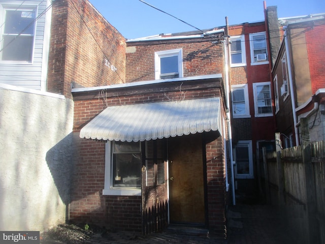 back of property with brick siding and fence