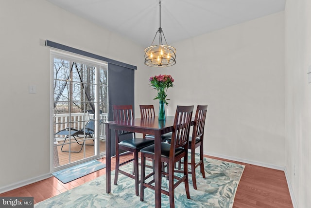 dining room with a chandelier, wood finished floors, and baseboards