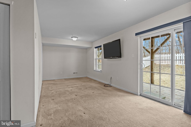 carpeted empty room featuring baseboards