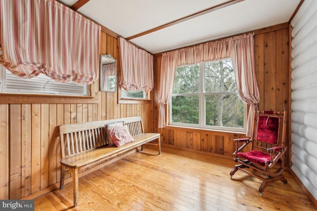 living area with hardwood / wood-style flooring, wooden walls, and log walls