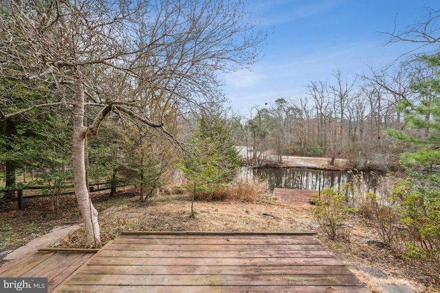 wooden deck featuring a water view and a wooded view