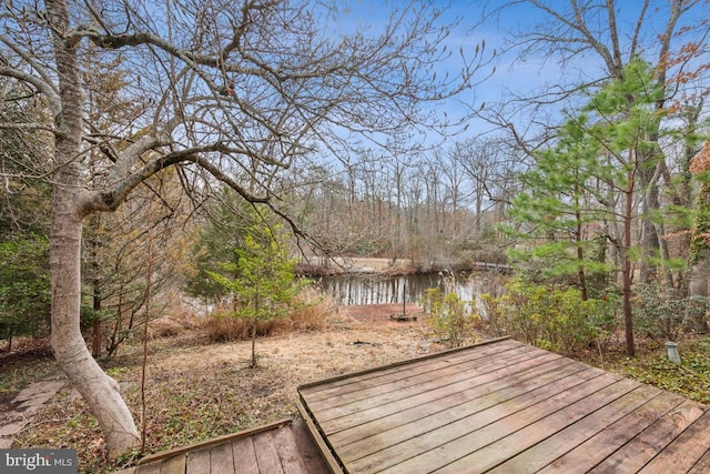 wooden deck with a water view and a view of trees