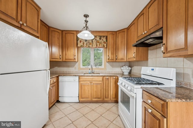 kitchen featuring light stone counters, brown cabinetry, a sink, white appliances, and under cabinet range hood