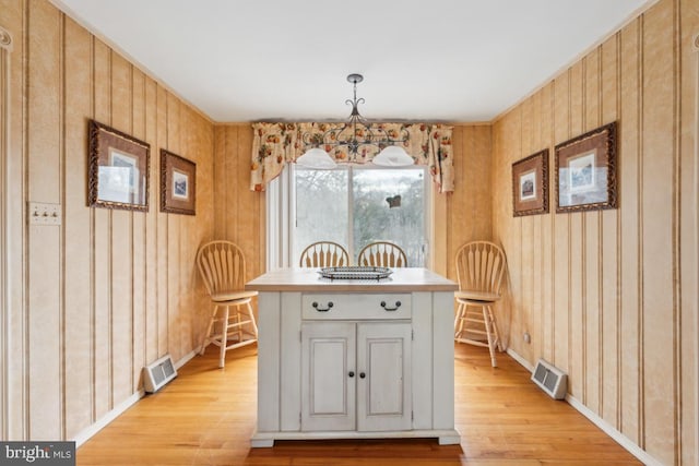 unfurnished dining area featuring light wood-style floors, baseboards, and visible vents