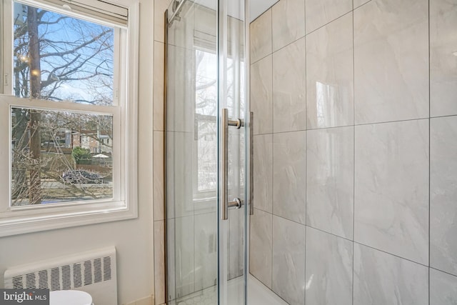 bathroom with a shower stall and radiator heating unit