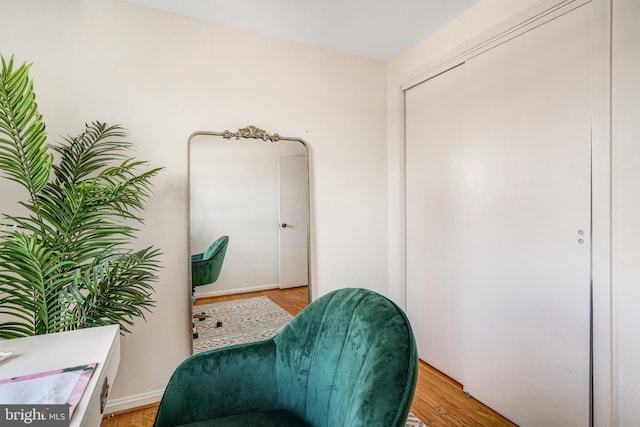 sitting room with baseboards and light wood-style flooring