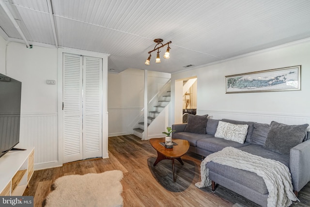 living area featuring wainscoting, wood finished floors, and stairs