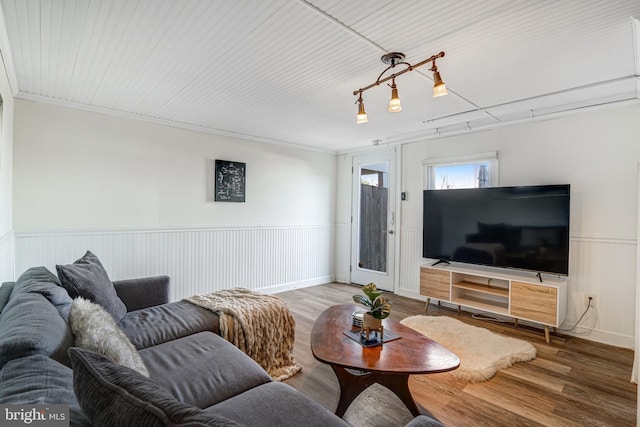 living room featuring a wainscoted wall and wood finished floors