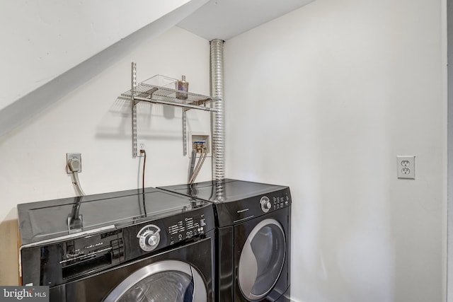 clothes washing area with washer and clothes dryer and laundry area